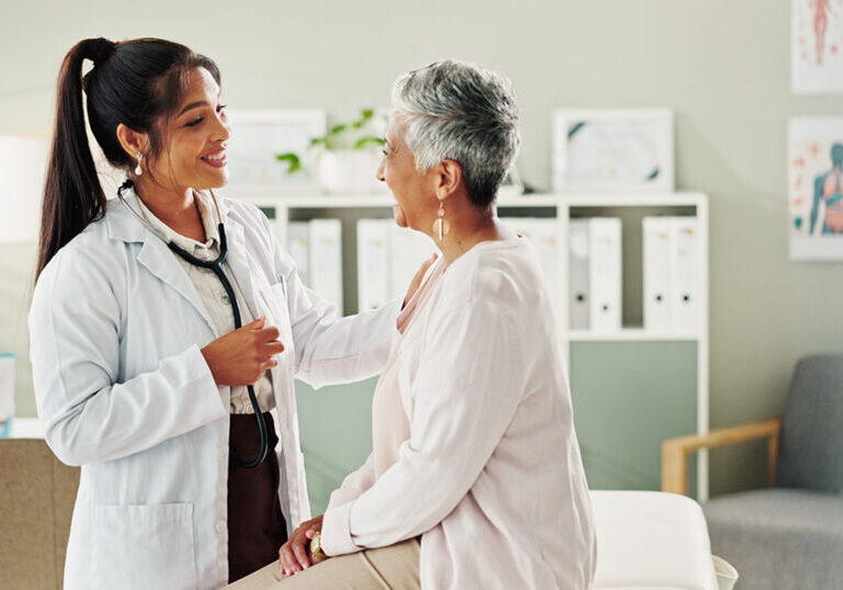 Doctor speaking reassuringly with a patient during a checkup, symbolizing how expat health insurance and global medical coverage fit into a U.S. expat’s overall financial plan