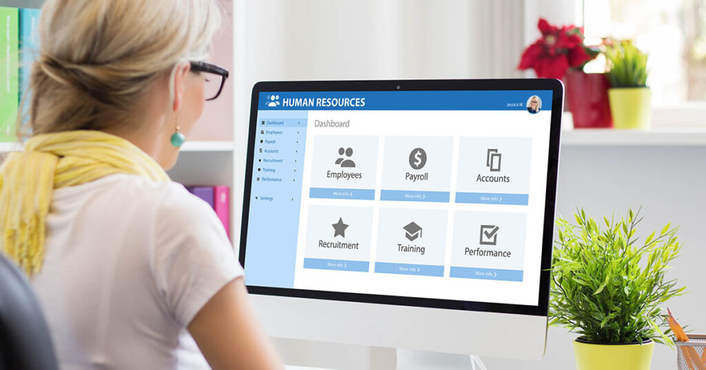 Woman works with dual human resources and payroll software on computer