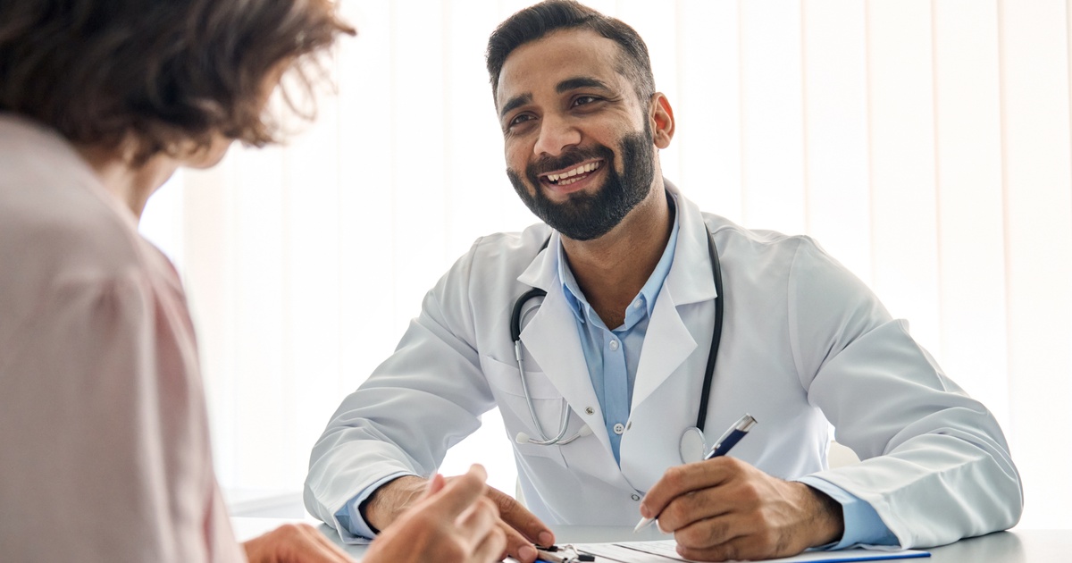 Physician listening to a professional explain details during a one-on-one meeting