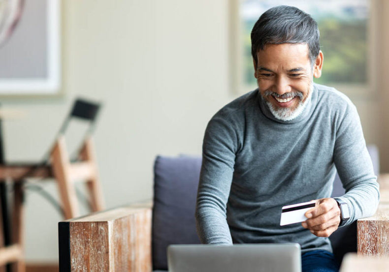 A man makes a purchase online while spending safely