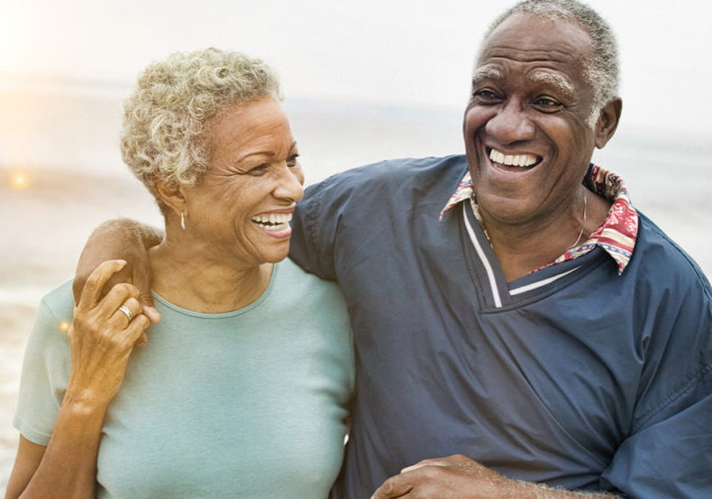 Senior couple discussing where they should retire while strolling the beach