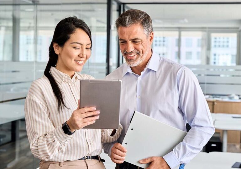 Coworkers discussing internal control policies over tablet